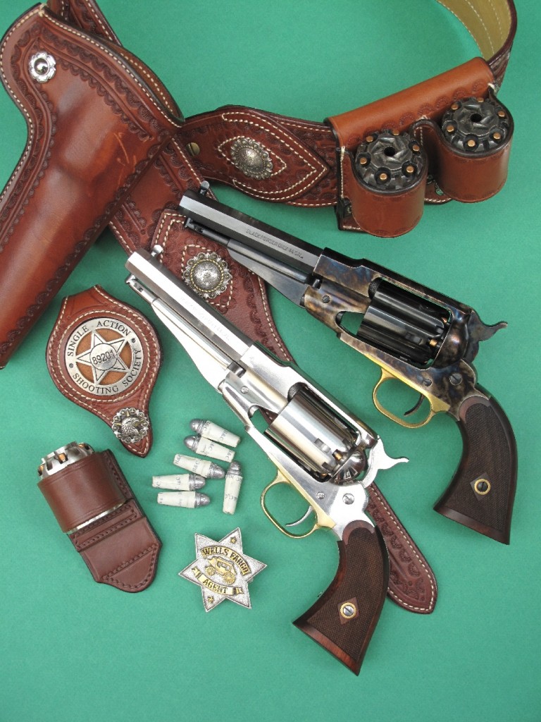 Deux répliques du revolver Remington New Model Army 1858, dans leur version fabriquée en Italie par Pietta qui les appelle « Sheriff », accompagnées par un ensemble ceinturon, holster, portes barillets et porte badge de la maison française La Sellerie du Thymerais, une réplique de badge Wells Fargo de la firme américaine Buffalo Brothers et six cartouches combustibles réalisées à l’aide du kit commercialisé par l’entreprise française H&C.