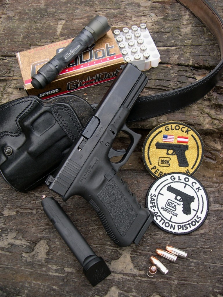 Ce Glock 17 de la troisième génération est ici accompagné d’une boîte de cartouches Speer Gold Dot, d’un holster de dos à port horizontal fabriqué Galco (USA) et d’une lampe torche SureFire A2 « Aviator » (USA).