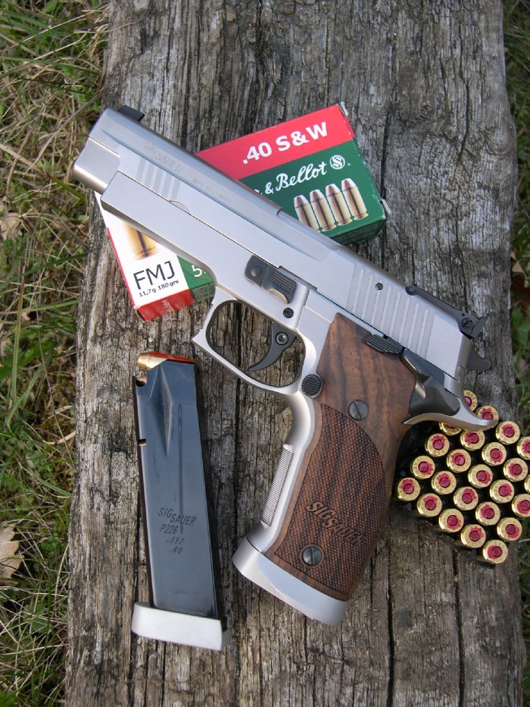 Mis au point par Sigarms en collaboration avec des tireurs sportifs de haut niveau, le modèle X-Five est considéré comme « Out of the box competition firearm », c’est-à-dire un pistolet capable de rivaliser au plus haut niveau des matches IPSC en classe standard sans nécessiter les améliorations habituellement apportées par les armuriers aux modèles de grande série. Le SIP P-226 X-Five est accompagné ici de son chargeur de rechange, d’une capacité de 12 coups en calibre .40 S&W et d’une boîte de cartouches fabriquées par la firme tchèque Sellier & Bellot.